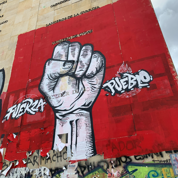 graffitti on a wall in Latin America: raised fist and words Fuera Pueblo. Credit: Dianna Torres