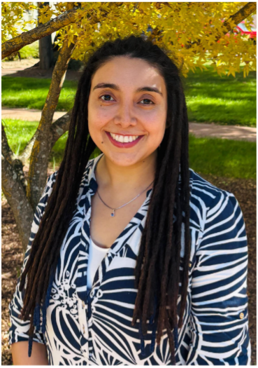 Portrait of Milena Páez Silva smiling outdoors, standing in front of a tree with yellow leaves.